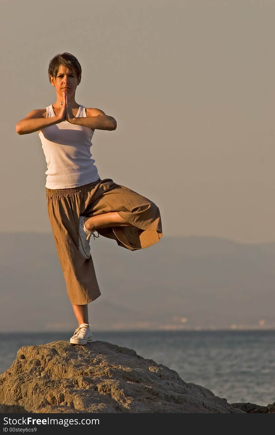 Woman making of yoga at the seaside. Woman making of yoga at the seaside