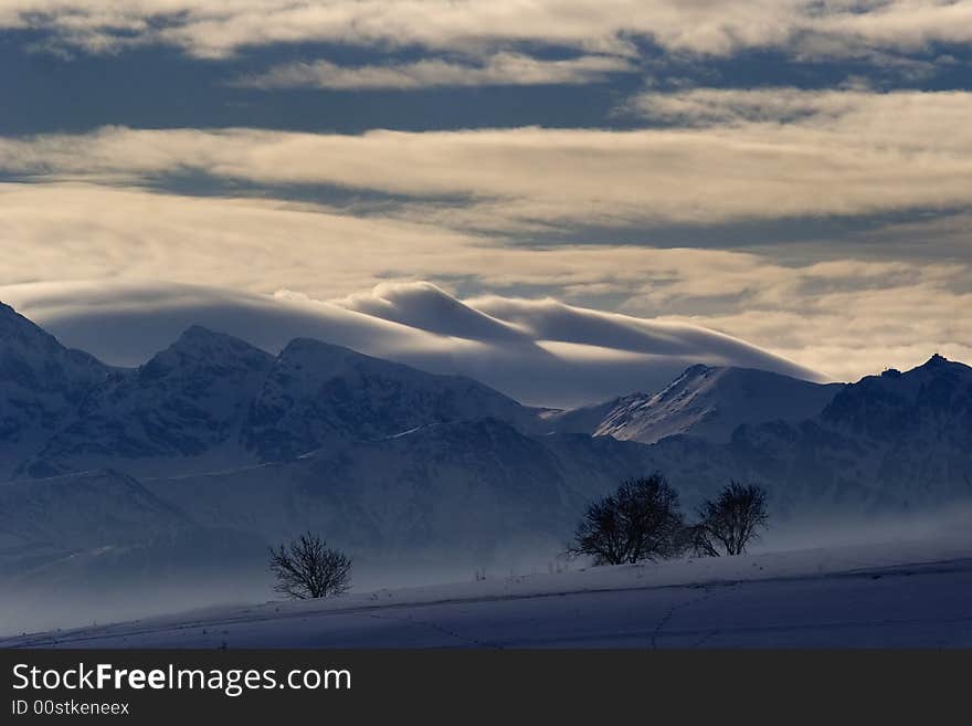 High mountains, tree and big white clouds