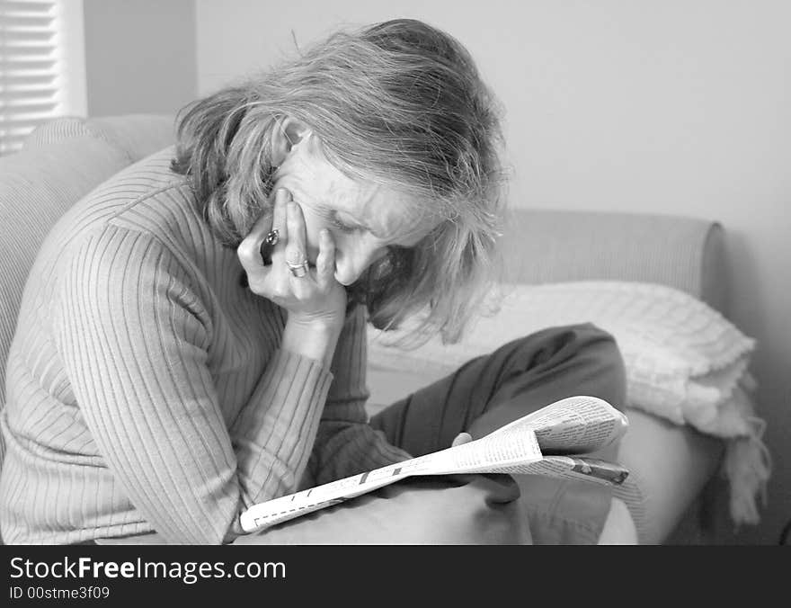 Woman working a crossword puzzle at home. Woman working a crossword puzzle at home.