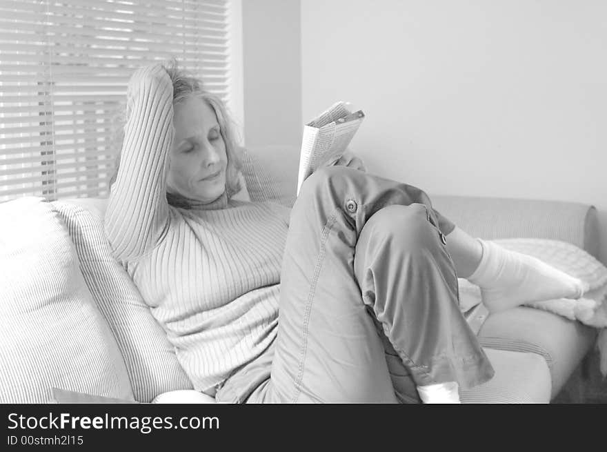 Woman working a crossword puzzle at home. Woman working a crossword puzzle at home.