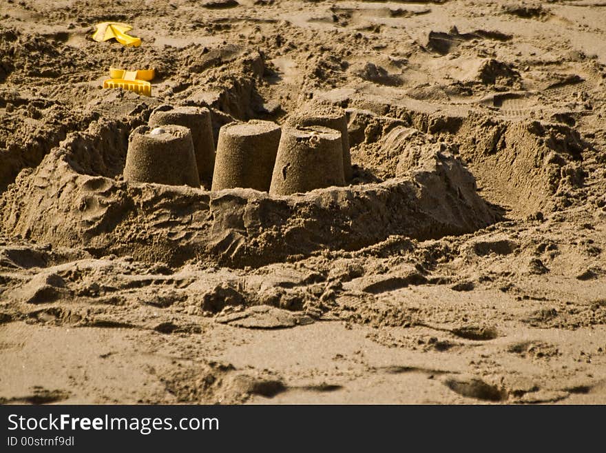 A spade and sandcastle built on a british beach in the height of the summer holidays. A spade and sandcastle built on a british beach in the height of the summer holidays