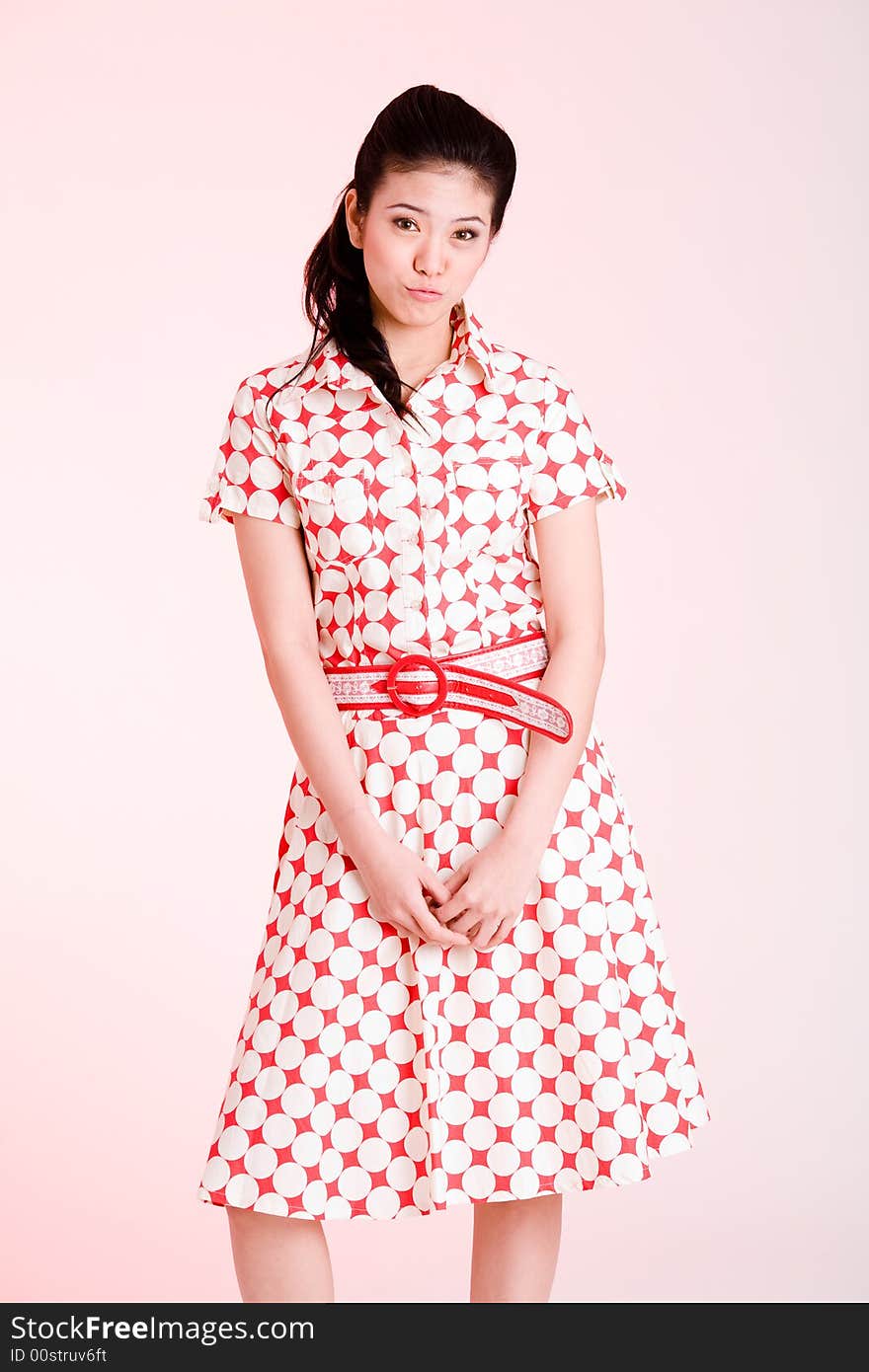 Girl in a red dress with white dots with an expressive face and gesture. Girl in a red dress with white dots with an expressive face and gesture