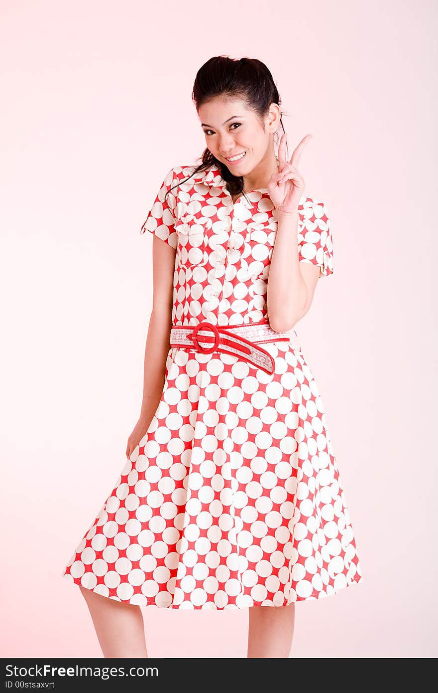 Girl in a red dress with white dots with an expressive face and gesture. Girl in a red dress with white dots with an expressive face and gesture