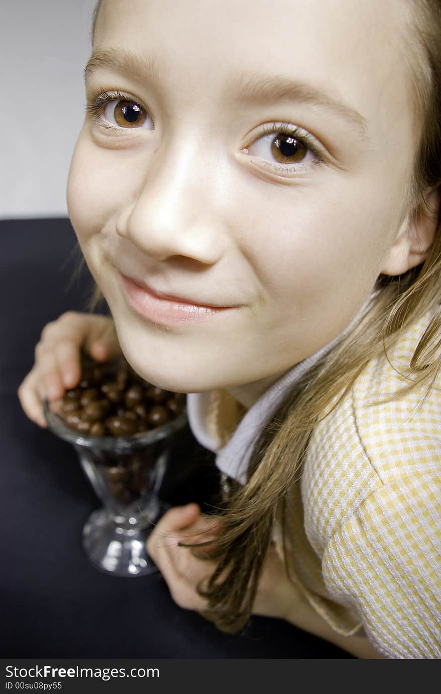 Young Girl Hovers Protectively Over Her Chocolate Treats. Young Girl Hovers Protectively Over Her Chocolate Treats