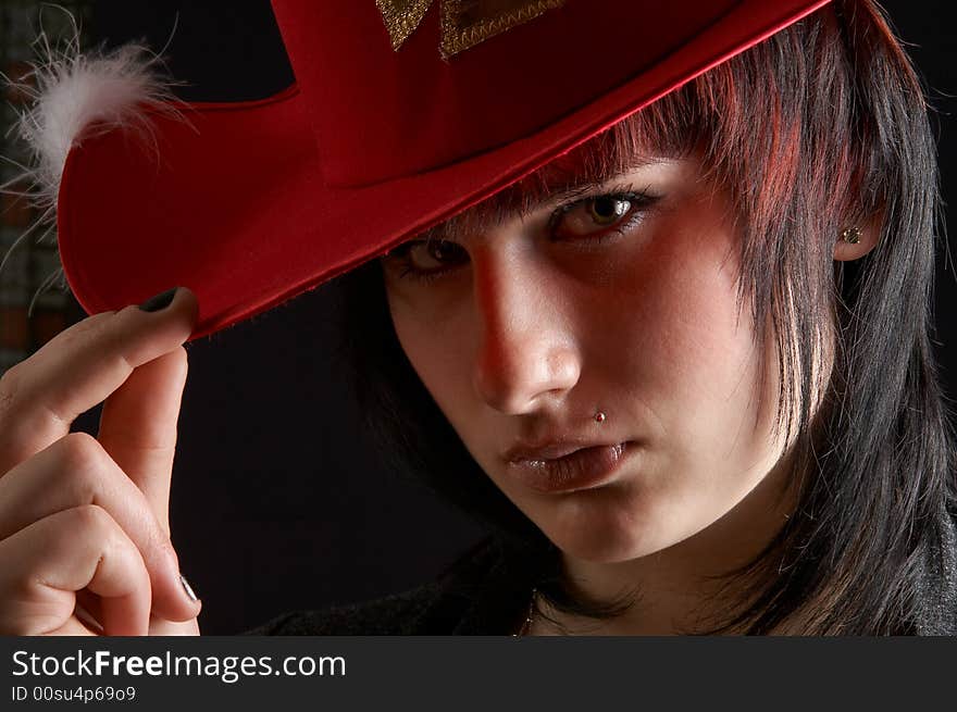 The girl in a red hat on a dark background. The girl in a red hat on a dark background