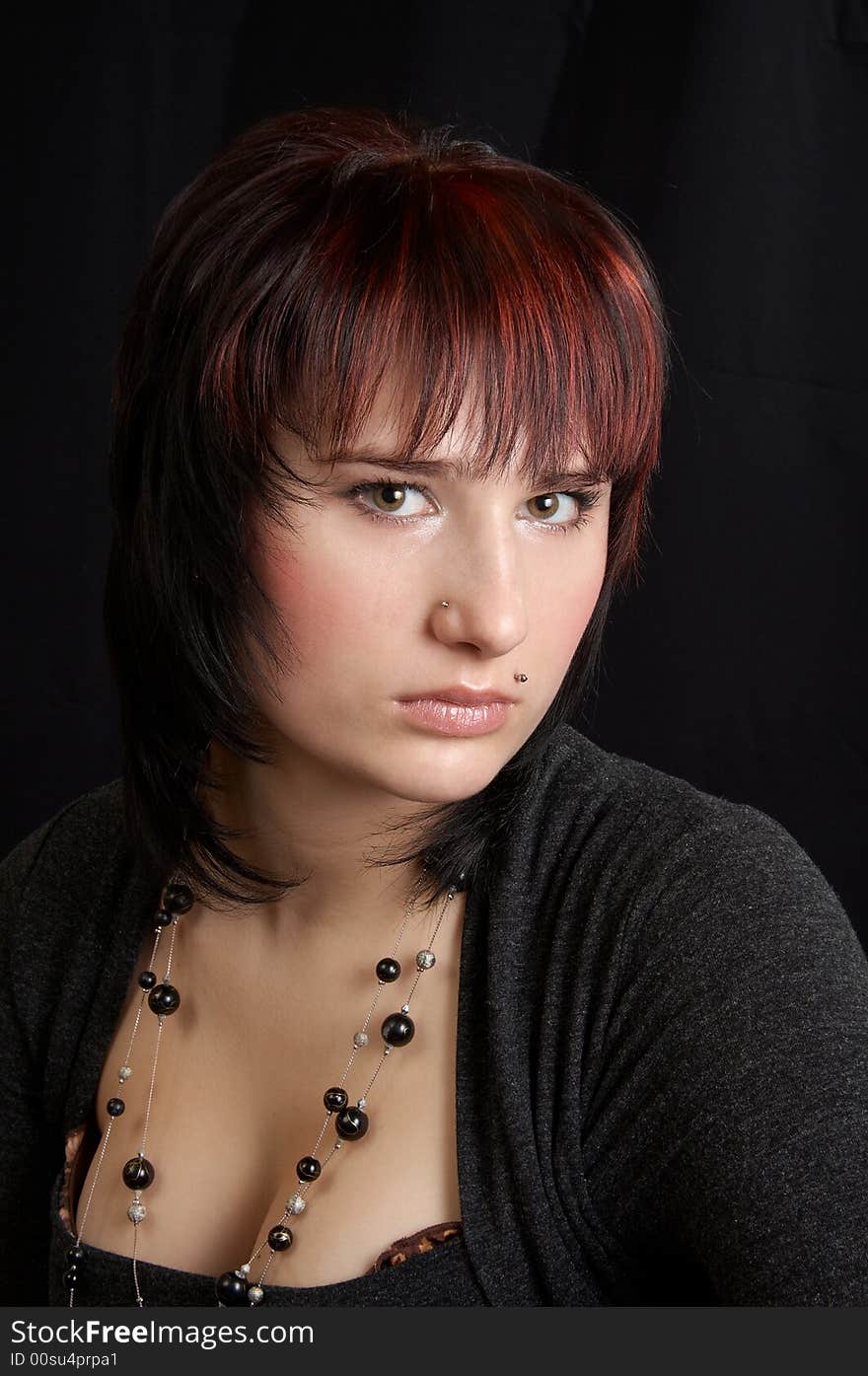 Portrait of the young woman on a black background