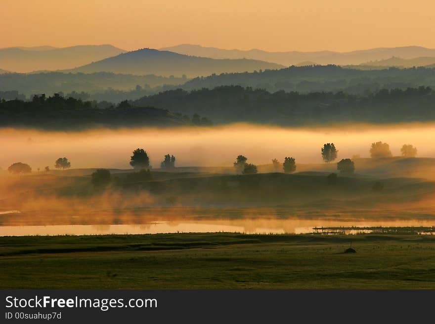 The heavy fog with orange color moving slowly on the lake. The heavy fog with orange color moving slowly on the lake