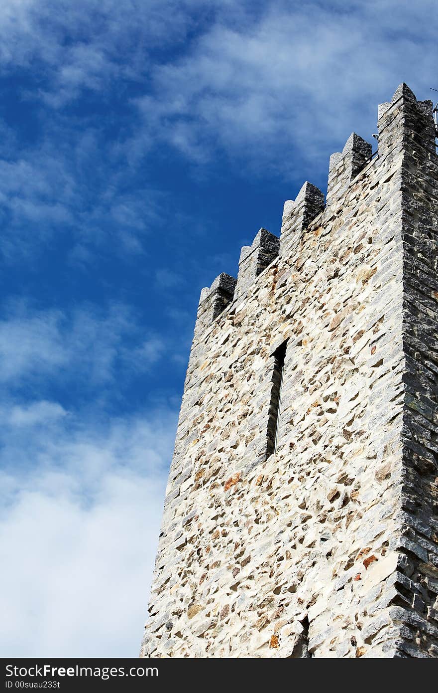 Detail of Medieval Castle tower against cloudy blue sky