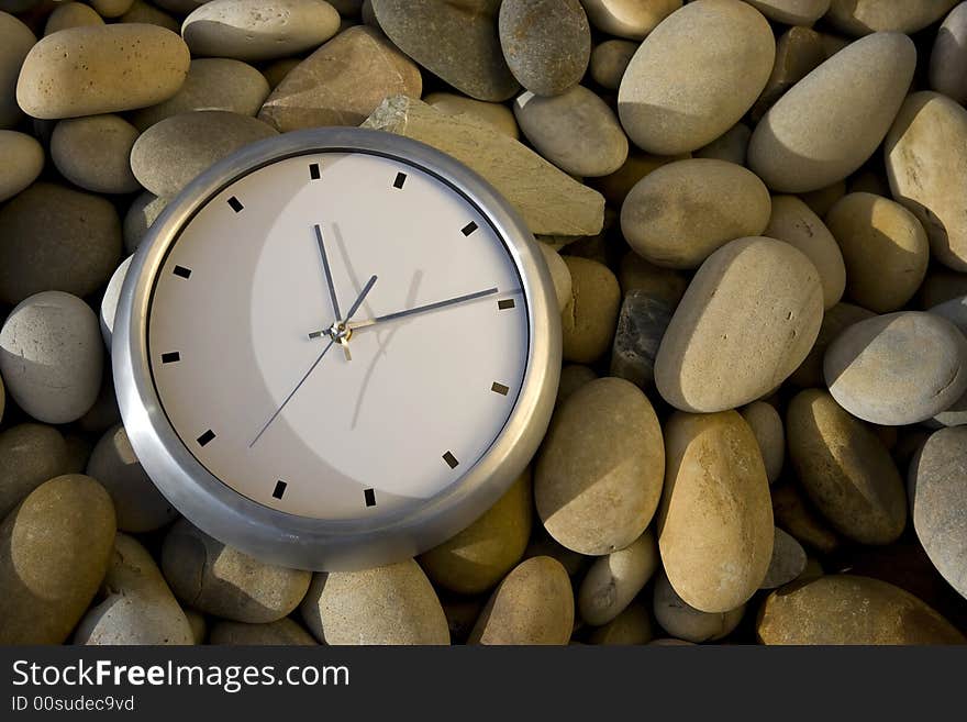 Big white clock over round peebles