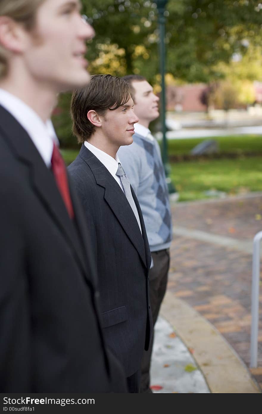 Three business men standing and smiling in same direction. Three business men standing and smiling in same direction