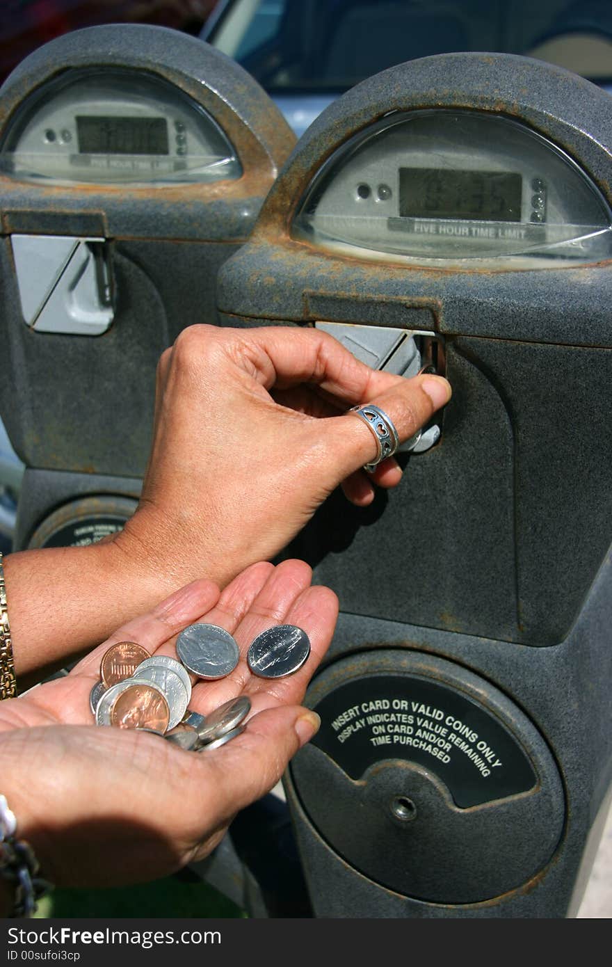 Inserting money in the parking meeter. Inserting money in the parking meeter