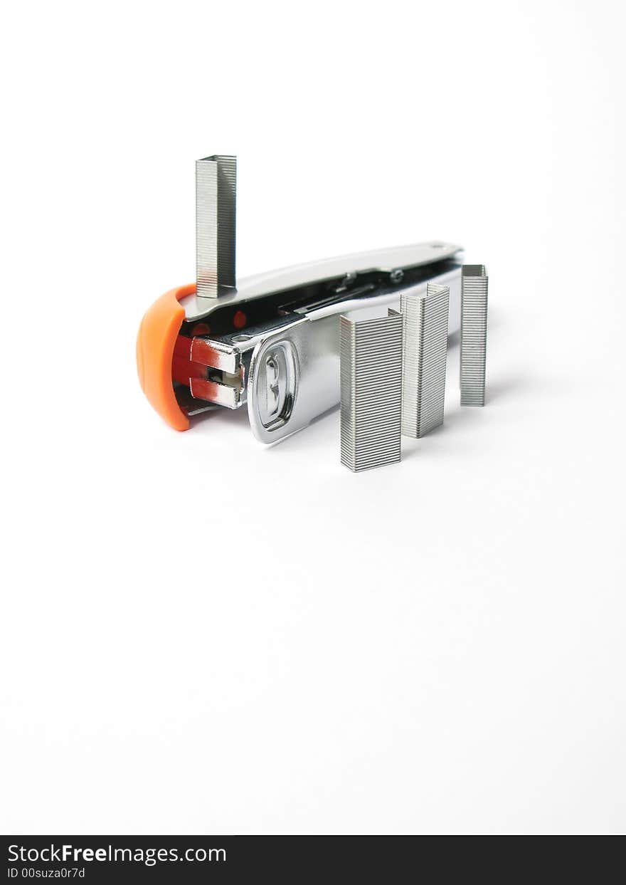 Silver and orange Stapler with staples on white background