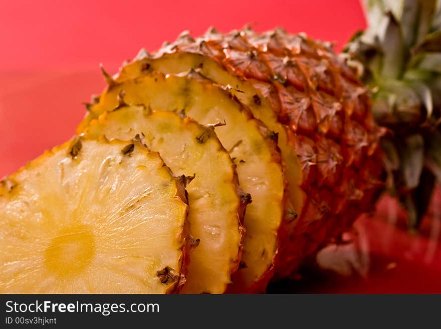 Food series: fresh ripe pineapple over red strawberry on the plate