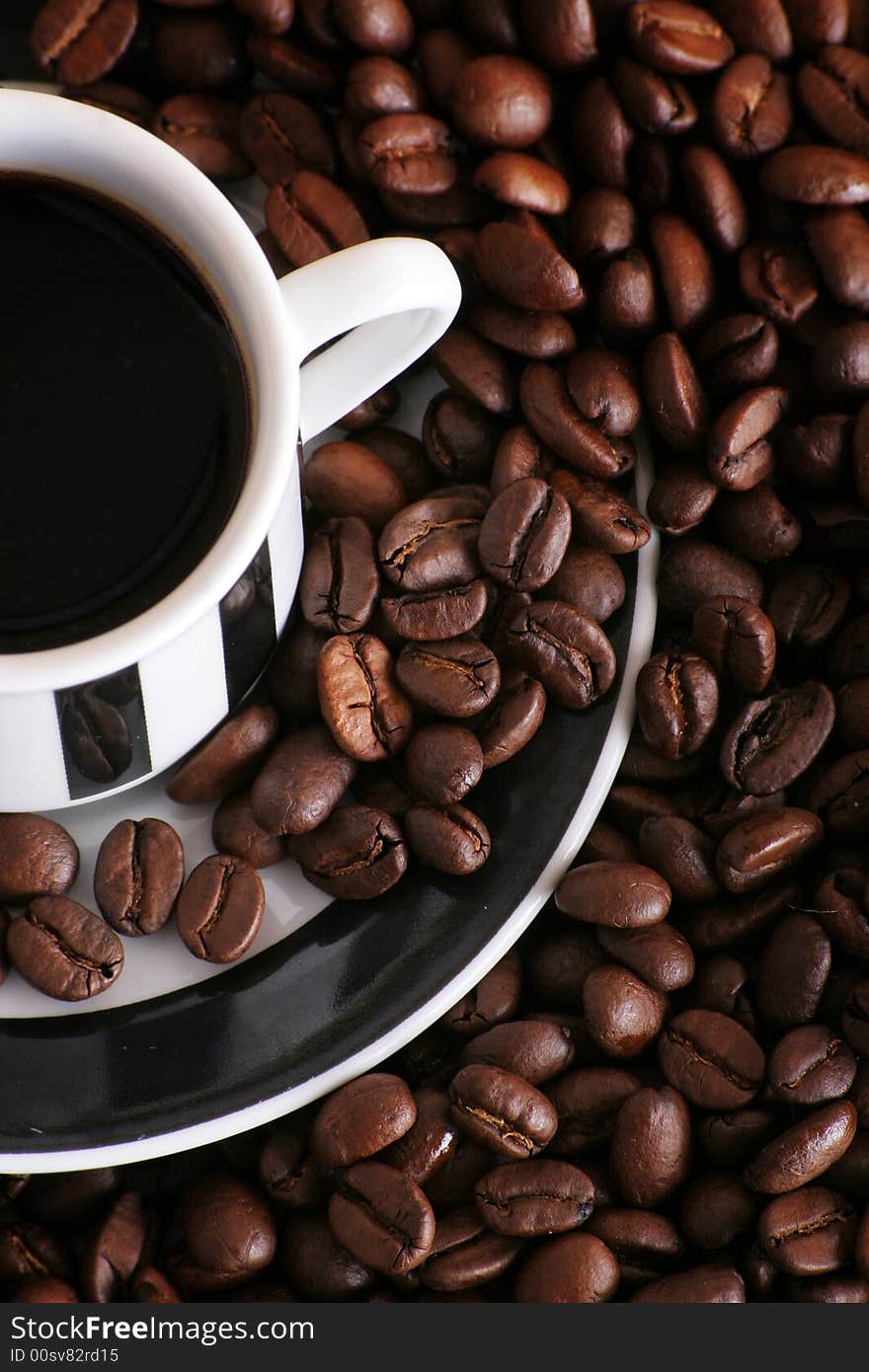 Some coffee beans and a cup of black coffee. Some coffee beans and a cup of black coffee