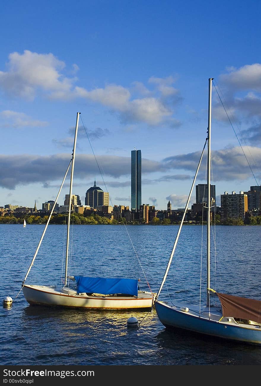 Two sailboats moored on the Cambridge side of the Charles River with the Boston skyline in the background. Two sailboats moored on the Cambridge side of the Charles River with the Boston skyline in the background.