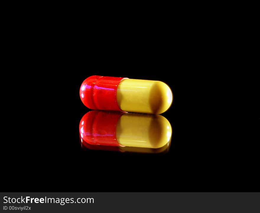 Pills on crisp black background with reflection