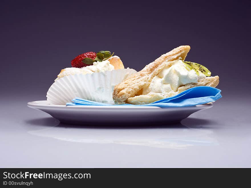 Cream pies on a plate on transparent violet background