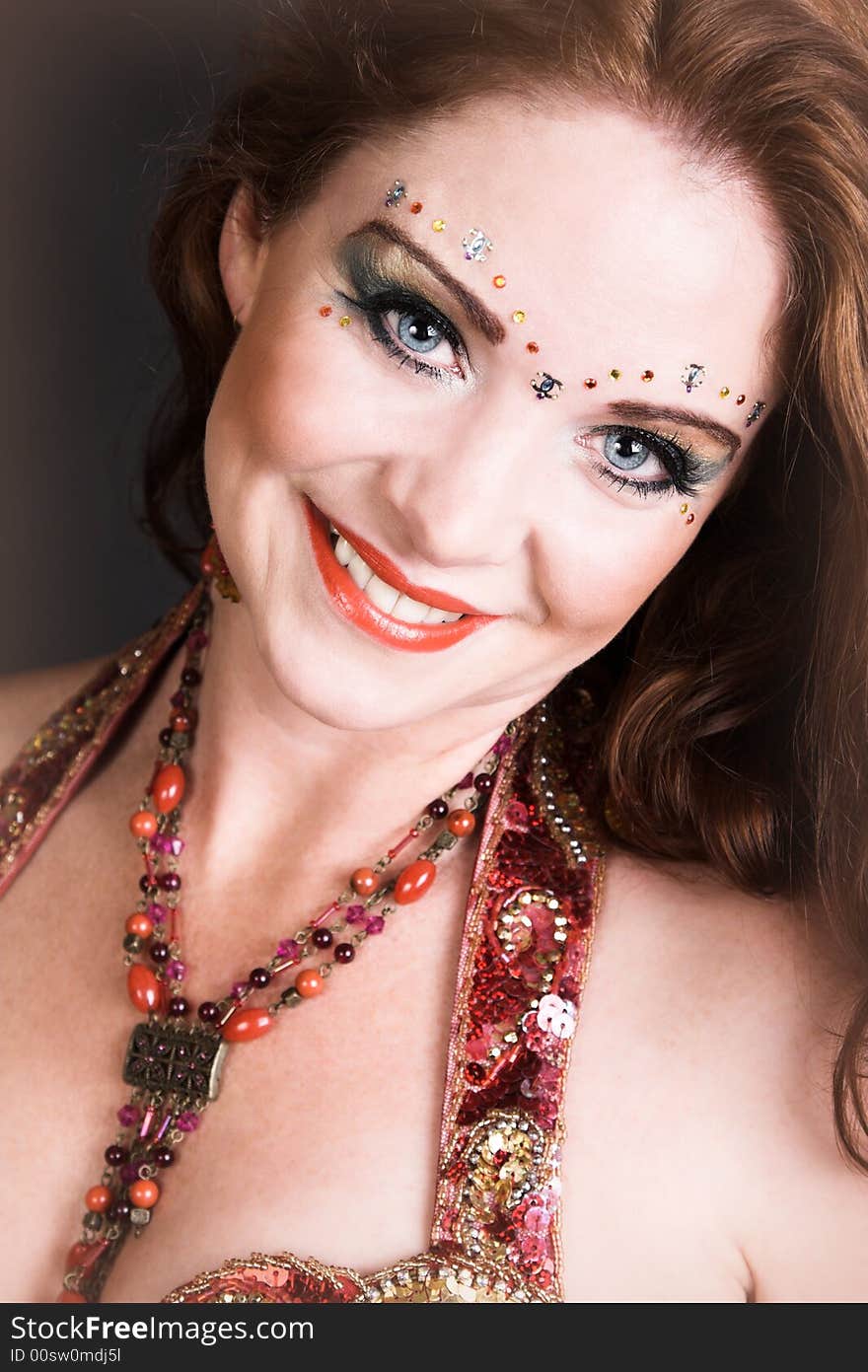 Belly Dancer wearing a red costume with jewelery. Belly Dancer wearing a red costume with jewelery