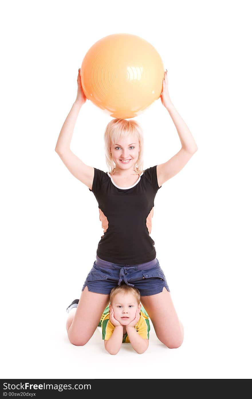 Young mother with a big ball and a small son do morning exercises. Young mother with a big ball and a small son do morning exercises