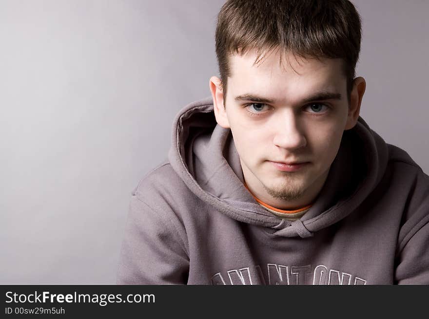 The young guy in studio on a grey background