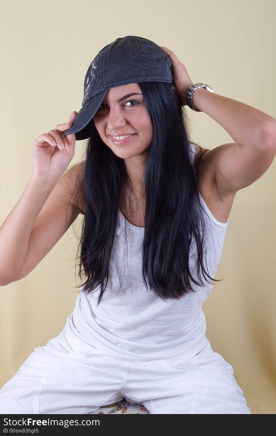 Smiling black hair young woman in cap portrait. studio shot.