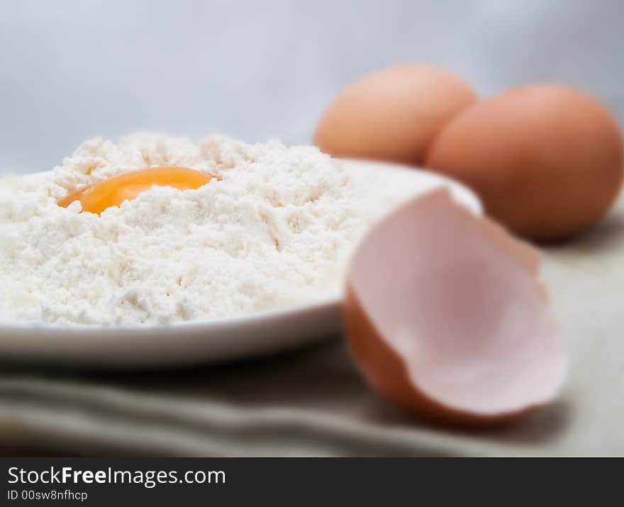 Egg and flour in a white plate. Egg and flour in a white plate