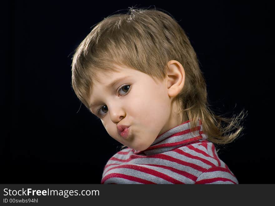 Grimace of Little boy on a black background. Grimace of Little boy on a black background