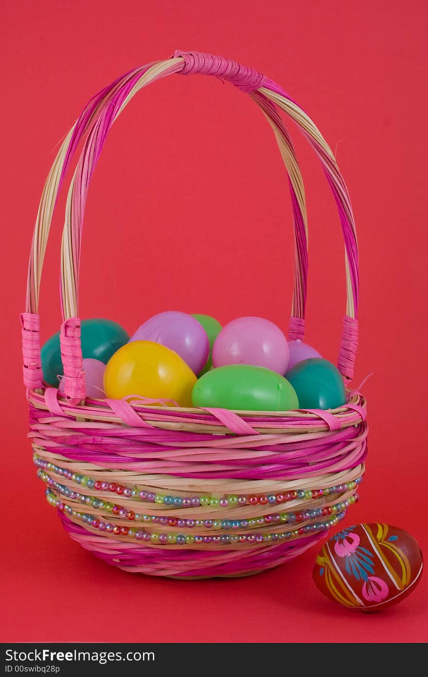 A basket full of plastic eggs (to be filled with candy) and pisanka egg on a side. A basket full of plastic eggs (to be filled with candy) and pisanka egg on a side