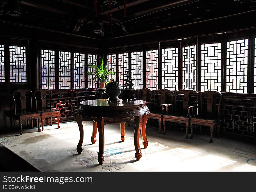 Traditional Chinese sittingroom with old desks, chairs and incense burner on desk