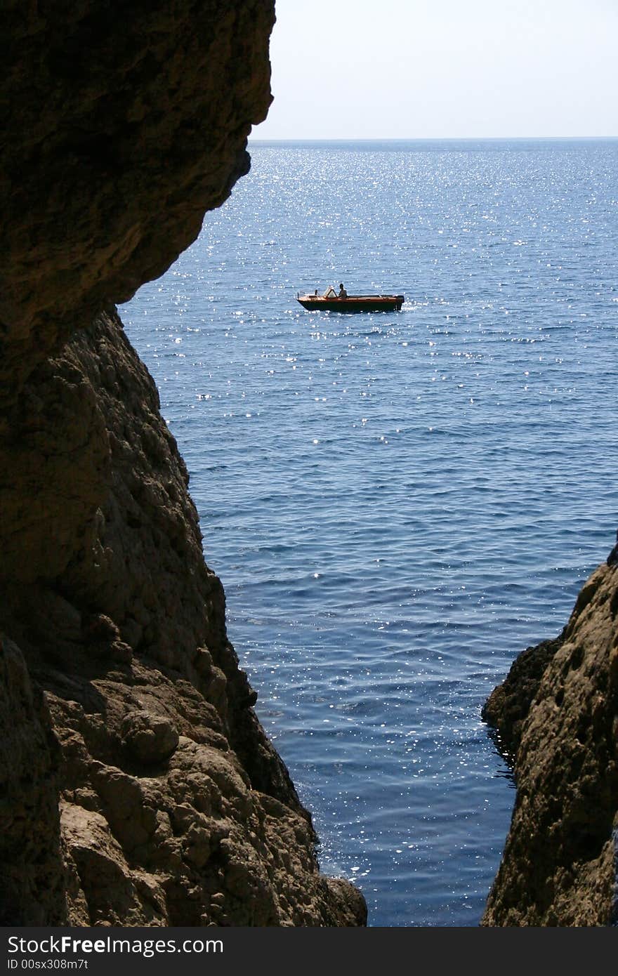 Motorboat sails seaborne, is seen from cave