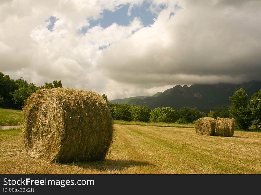 Haystacks Under A Moody Sky