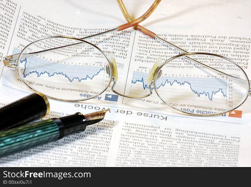 Glasses, a stock chart and a pen. Glasses, a stock chart and a pen