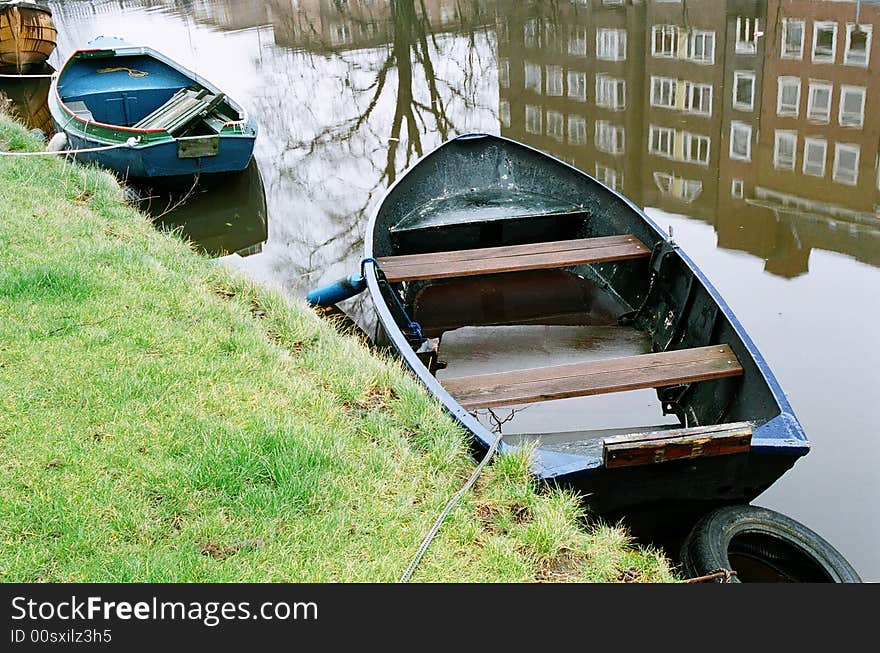 Parking boats in a still water canal in Amsterdam, Netherlands. Parking boats in a still water canal in Amsterdam, Netherlands