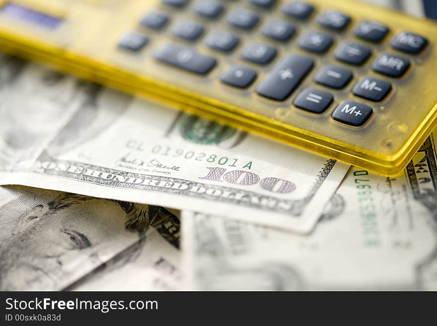 Yellow calculator on a pile of dollars. Yellow calculator on a pile of dollars