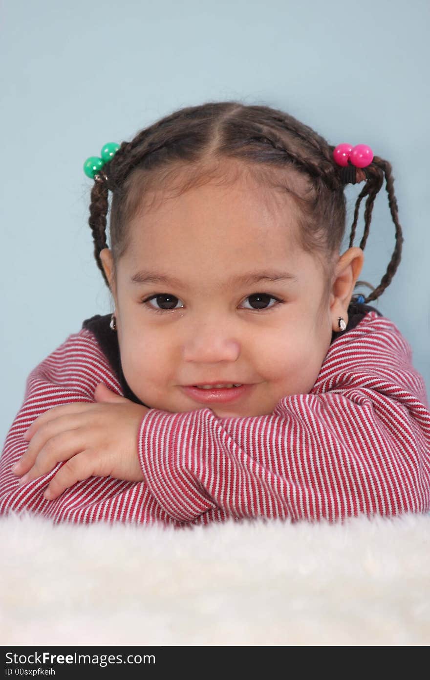 Toddler girl posed resting her chin on her arms