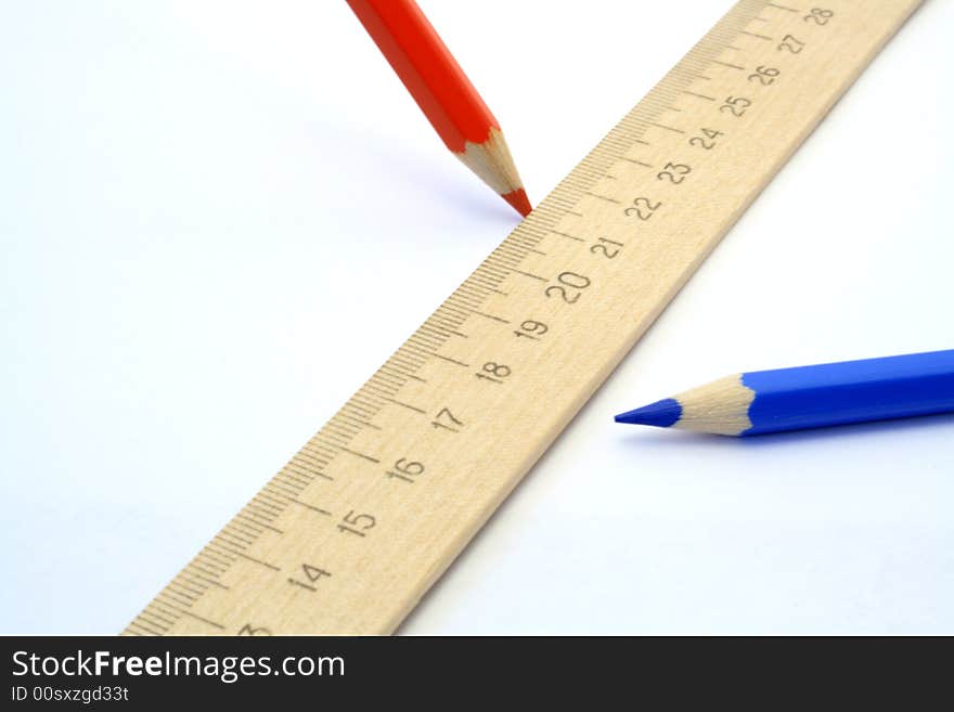 Two coloured pencils and wooden ruler on white background. Two coloured pencils and wooden ruler on white background