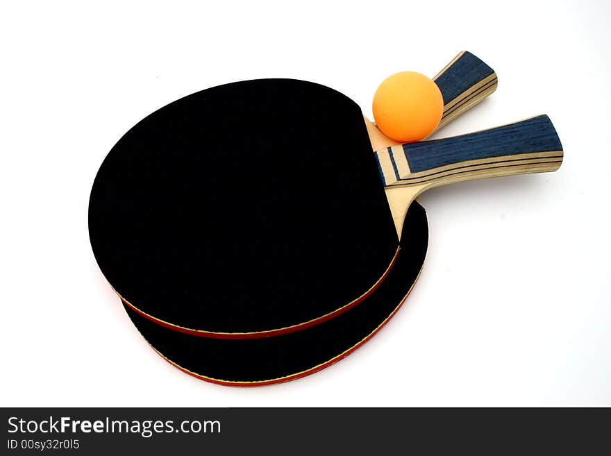 Ping pong paddles and an orange ball over a white surface