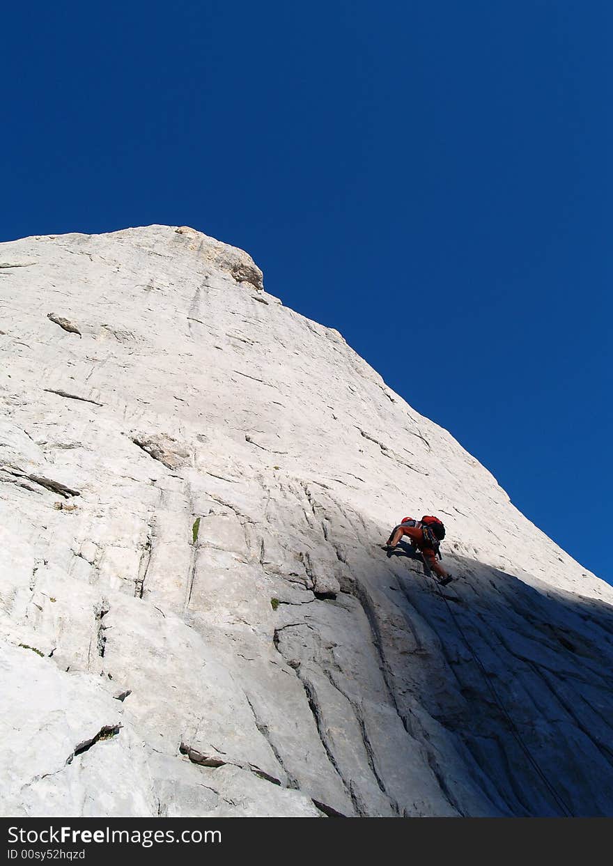 Climber leads first pitch on east face of Picu Urriellu