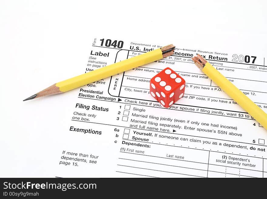 Red die and broken pencil over 1040 tax form. Red die and broken pencil over 1040 tax form