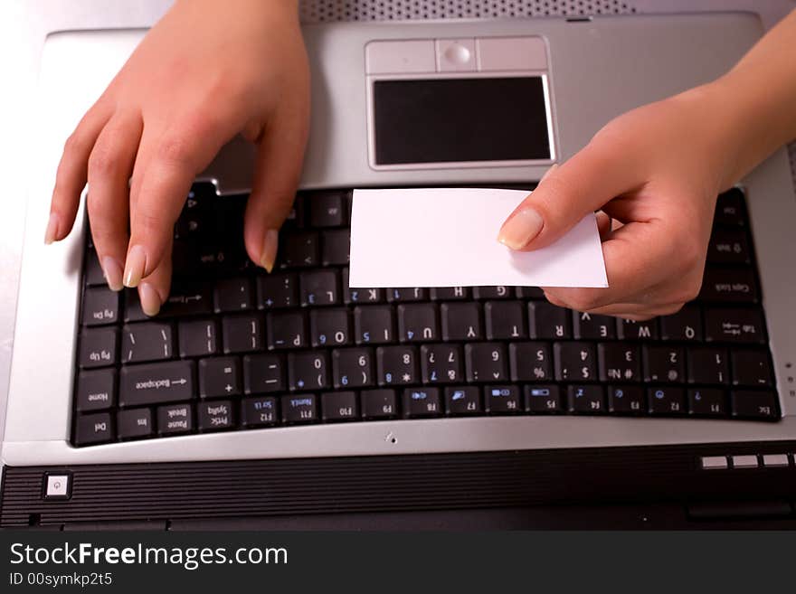 Young woman's hands with computer keybord and business card