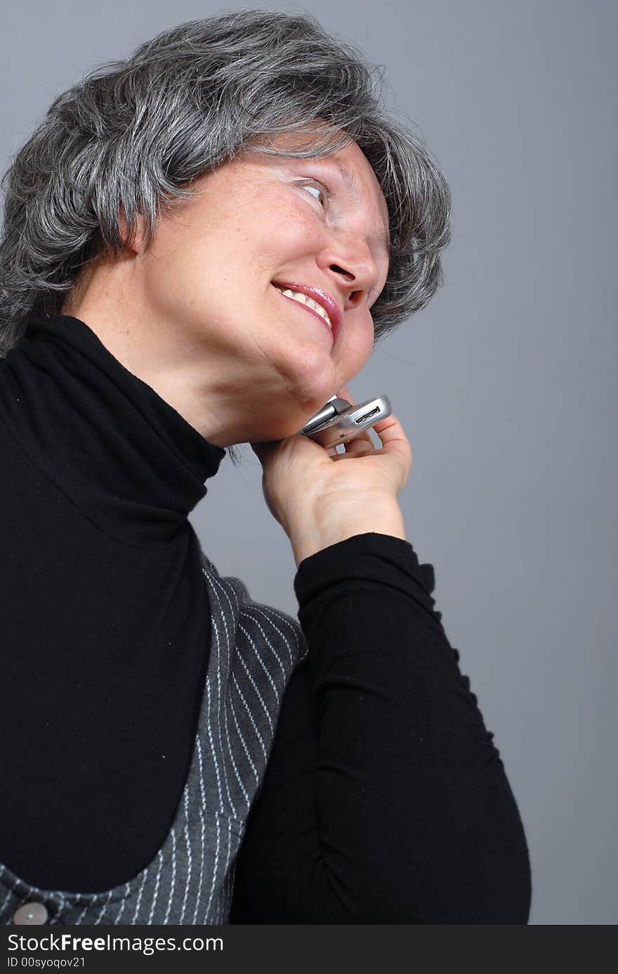 Naturally beautiful older woman talking on a cell phone. Naturally beautiful older woman talking on a cell phone