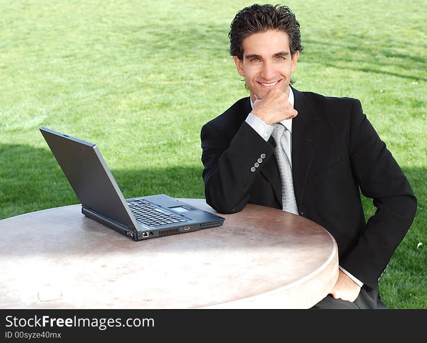 Confident and successful young adult businessman working on his laptop computer. Confident and successful young adult businessman working on his laptop computer