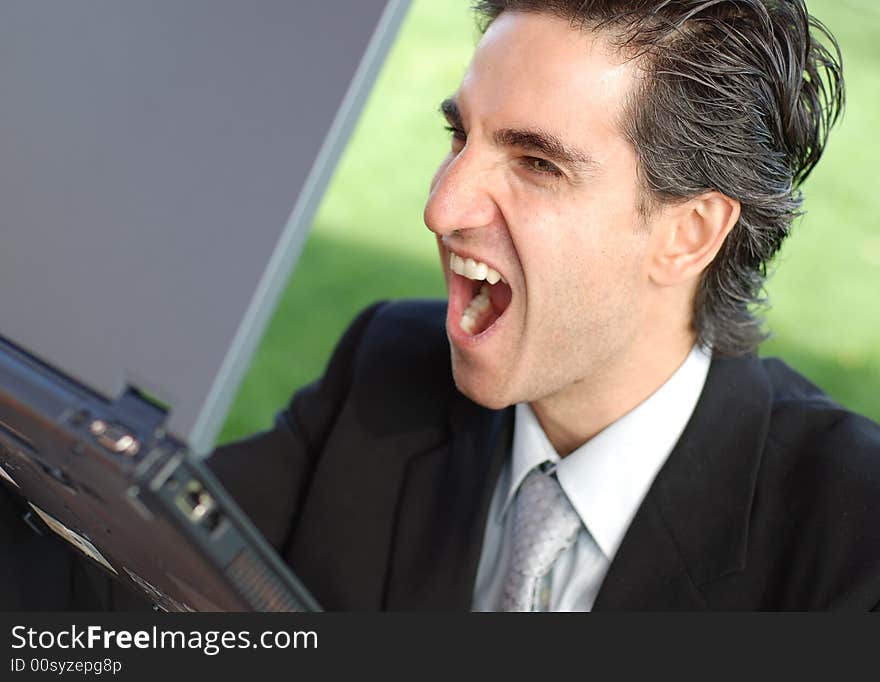 Business is very angry and screaming at his laptop. Business is very angry and screaming at his laptop