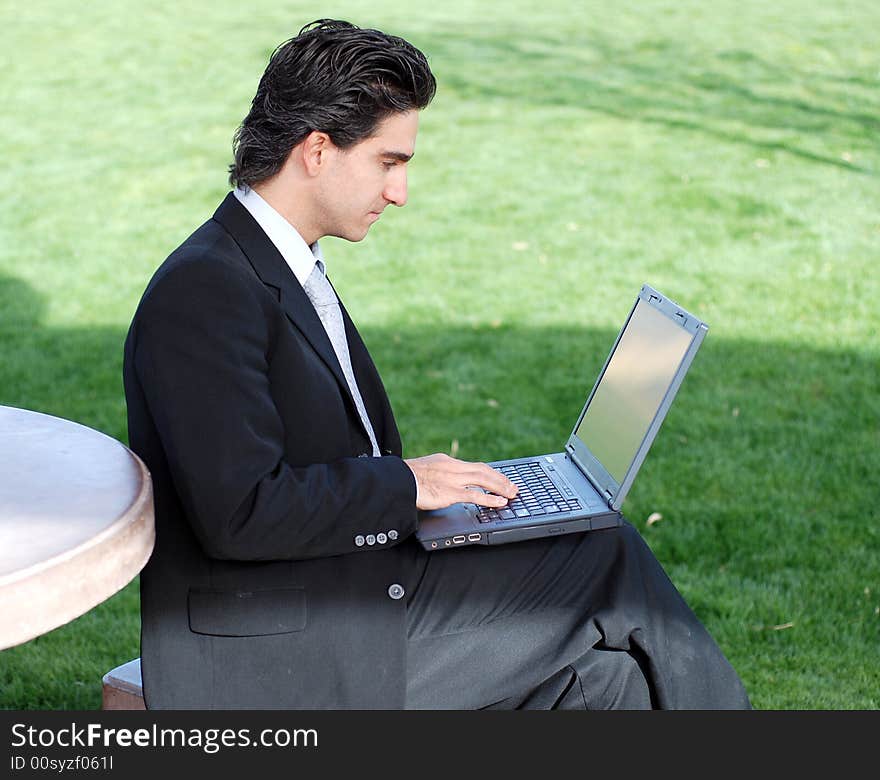 Confident and successful young adult businessman working on his laptop computer