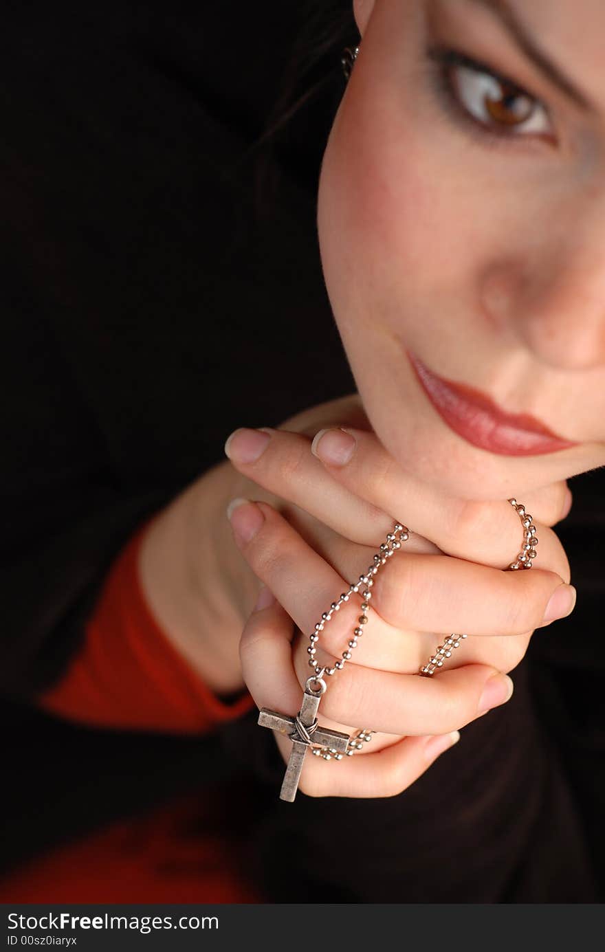 A woman is praying to god with hope(focus is on the cross). A woman is praying to god with hope(focus is on the cross)