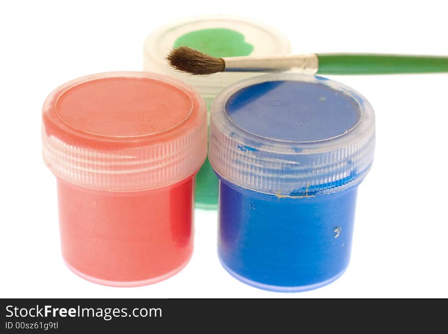 Brush lying over three jars with paint. Brush lying over three jars with paint