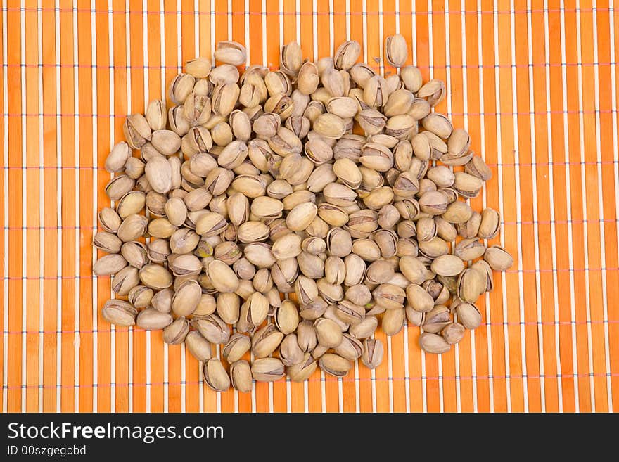 A Pile Of Pistachios On Bamboo Table-cloth