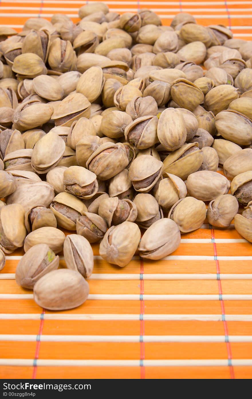 A Pile Of Pistachios On Bamboo Table-cloth