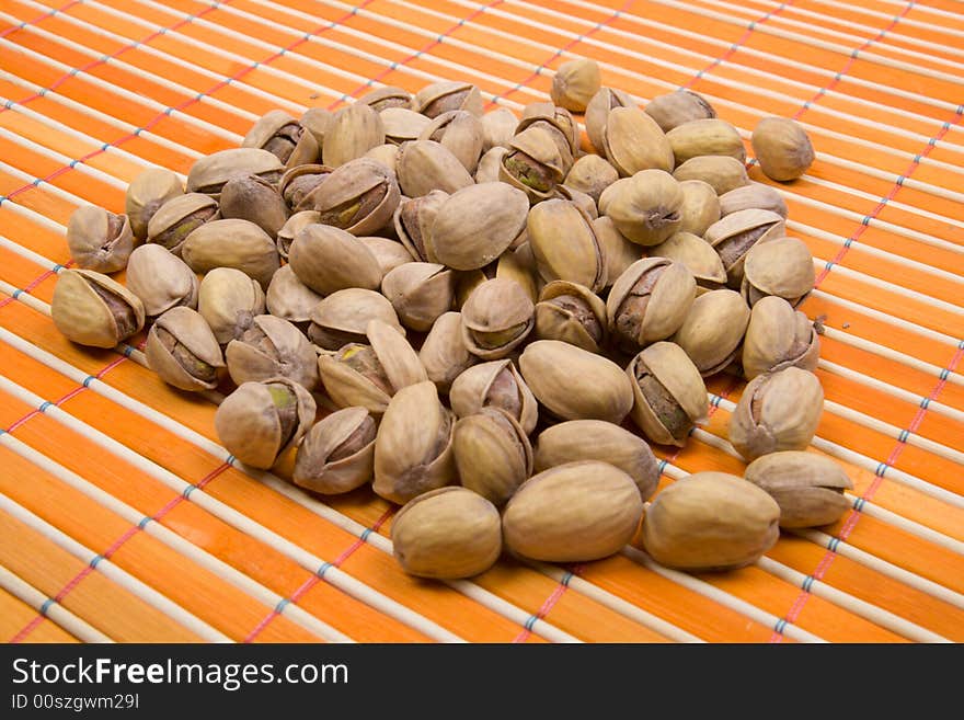 A Pile Of Pistachios On Bamboo Table-cloth