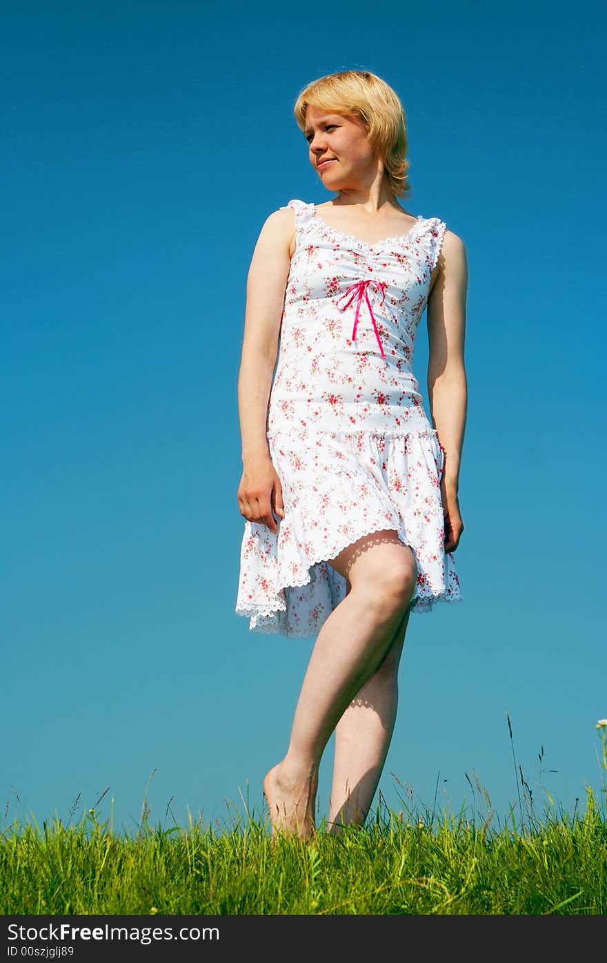 Woman stand on green grass under blue sky